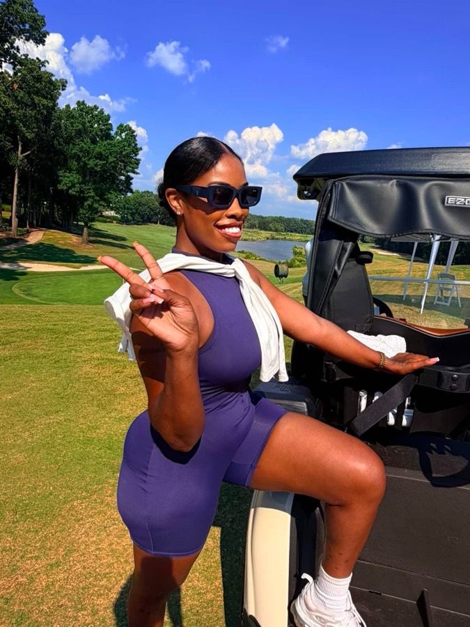 Girls Girl Golfing member throwing a peace sign next to a golf cart