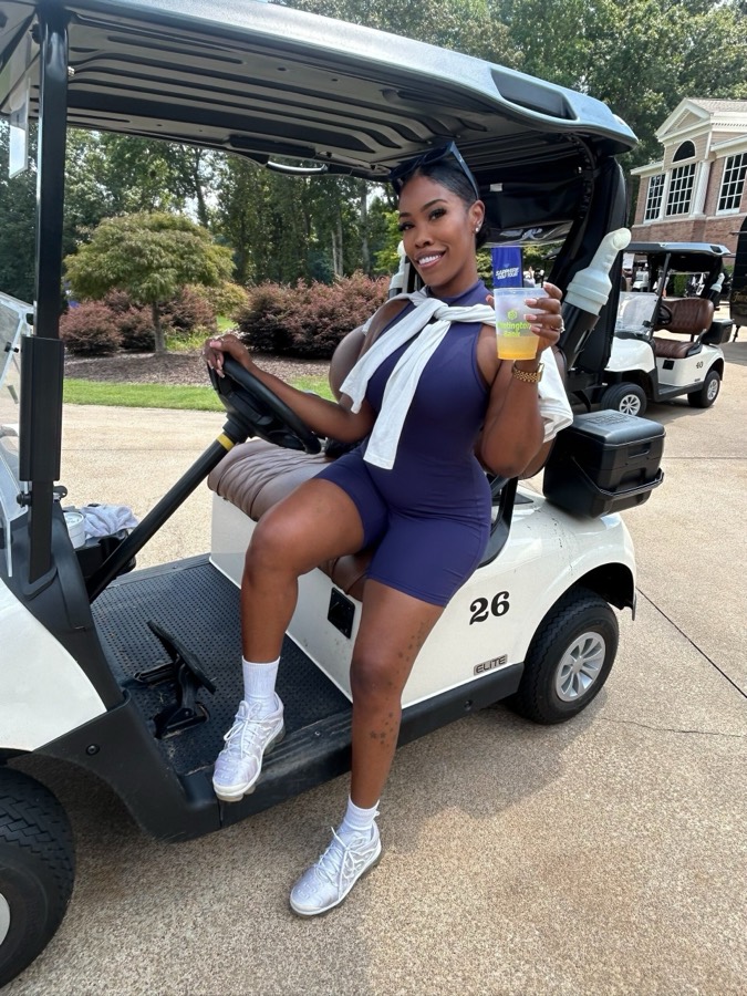 Girls Girl Golfing member smiling in a golf cart at the clubhouse
